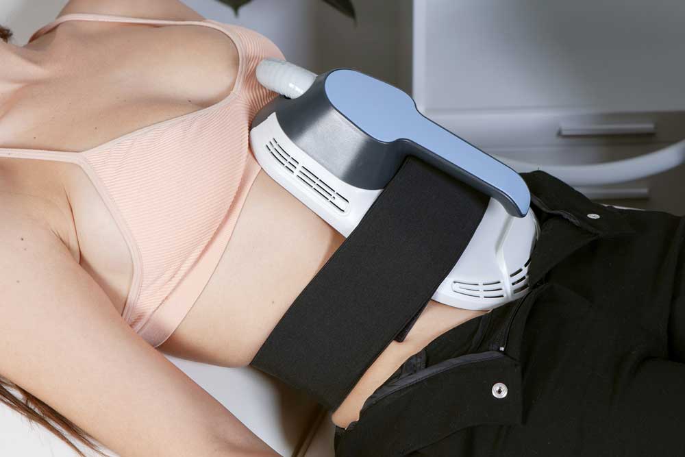 Femme qui se fait mincir le ventre avec une machine d'amincisssement electromagnetique 